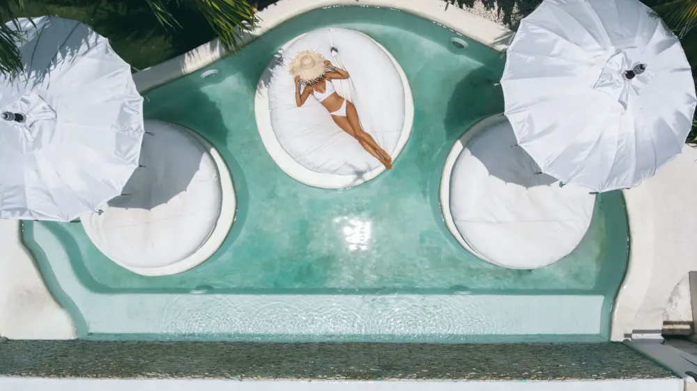 Aerial view of woman relaxing on a float in a pool